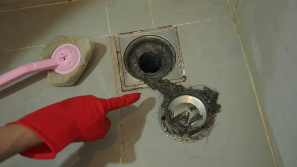 Drain cleaning. Clogged and dirty sewer pipes floor drain. Full of hair and accumulated clogged grease. Maintenance the floor drain sewage system in bathroom. fixing clean wash and unclog a drain.