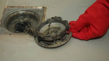 Kanalizasyon temizliği. Tıkanmış ve kirli kanalizasyon boruları boşaltılıyor. Saçları ve birikmiş tıkanmış yağlarla dolu. Banyodaki kanalizasyon sistemini tamir et. Temiz yıkama ve tıkanıklık giderlerini onarmak.