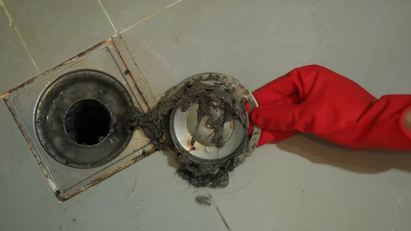 Drain cleaning. Clogged and dirty sewer pipes floor drain. Full of hair and accumulated clogged grease. Maintenance the floor drain sewage system in bathroom. fixing clean wash and unclog a drain.