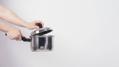Pot cleaning Man hand on white background cleaning the non stick pot with handy dish washing sponge which yellow color on the soft side and green on hard side for hygiene after cook. Electric pot