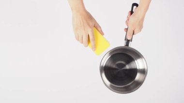 Pot cleaning Man hand on white background cleaning the non stick pot with handy dish washing sponge which yellow color on the soft side and green on hard side for hygiene after cook. Electric pot