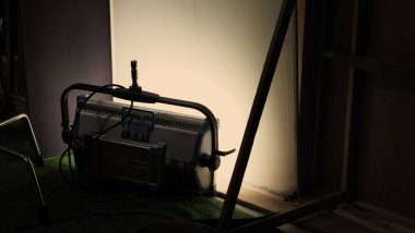 Film light for video production camera in studio set. Use as studio photo shoot light. Big LED spot light 5000w and diffuser or black panel create light like sun light can make daytime or golden hour