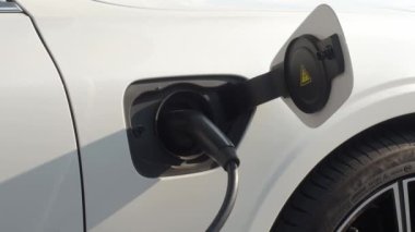 EV vagonu yükleniyor. Araba parkında EV şarj aletini kullanarak hızlı şarj etmek ki bu da gelecekteki ulaşım enerji teknolojisi demek. EV Charger araba istasyonu şarj oluyor. Elektrik motoru için AC veya DC soket prizi kullanın..
