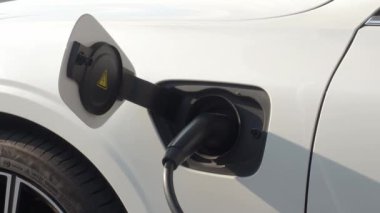 EV vagonu yükleniyor. Araba parkında EV şarj aletini kullanarak hızlı şarj etmek ki bu da gelecekteki ulaşım enerji teknolojisi demek. EV Charger araba istasyonu şarj oluyor. Elektrik motoru için AC veya DC soket prizi kullanın..