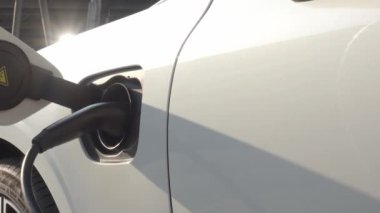 EV vagonu yükleniyor. Araba parkında EV şarj aletini kullanarak hızlı şarj etmek ki bu da gelecekteki ulaşım enerji teknolojisi demek. EV Charger araba istasyonu şarj oluyor. Elektrik motoru için AC veya DC soket prizi kullanın..