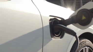 EV vagonu yükleniyor. Araba parkında EV şarj aletini kullanarak hızlı şarj etmek ki bu da gelecekteki ulaşım enerji teknolojisi demek. EV Charger araba istasyonu şarj oluyor. Elektrik motoru için AC veya DC soket prizi kullanın..