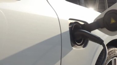 EV vagonu yükleniyor. Araba parkında EV şarj aletini kullanarak hızlı şarj etmek ki bu da gelecekteki ulaşım enerji teknolojisi demek. EV Charger araba istasyonu şarj oluyor. Elektrik motoru için AC veya DC soket prizi kullanın..