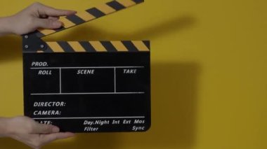 Sinema kamerası kaydının önüne film tahtası ya da film şeridi çarpar. El ele tutuşup boş film tahtasını tutarak alkışlıyoruz. Video prodüksiyonu için açık ve kapalı film sayfası. film üretimi.
