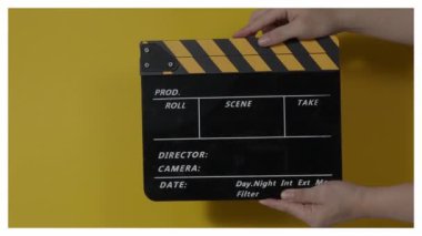 Sinema kamerası kaydının önüne film tahtası ya da film şeridi çarpar. El ele tutuşup boş film tahtasını tutarak alkışlıyoruz. Video prodüksiyonu için açık ve kapalı film sayfası. film üretimi.