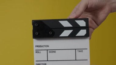 Sinema kamerası kaydının önüne film tahtası ya da film şeridi çarpar. El ele tutuşup boş film tahtasını tutarak alkışlıyoruz. Video prodüksiyonu için açık ve kapalı film sayfası. film üretimi.