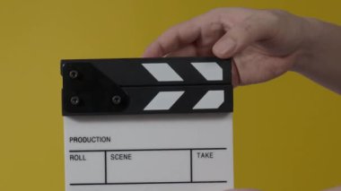 Sinema kamerası kaydının önüne film tahtası ya da film şeridi çarpar. El ele tutuşup boş film tahtasını tutarak alkışlıyoruz. Video prodüksiyonu için açık ve kapalı film sayfası. film üretimi.