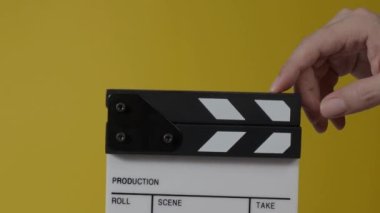 Sinema kamerası kaydının önüne film tahtası ya da film şeridi çarpar. El ele tutuşup boş film tahtasını tutarak alkışlıyoruz. Video prodüksiyonu için açık ve kapalı film sayfası. film üretimi.