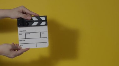Sinema kamerası kaydının önüne film tahtası ya da film şeridi çarpar. El ele tutuşup boş film tahtasını tutarak alkışlıyoruz. Video prodüksiyonu için açık ve kapalı film sayfası. film üretimi.
