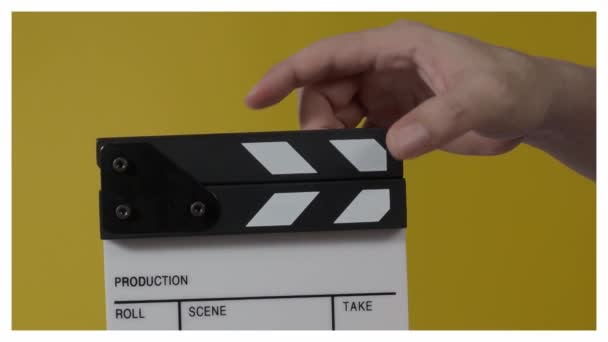 フィルムスレートまたは映画のカメラの記録の前で打つ映画のクラッパーボード 手を閉じて空のフィルムスレートを保持し それを拍手 ビデオ制作のためにフィルムスレートを開いて閉じます 映画製作 — ストック動画