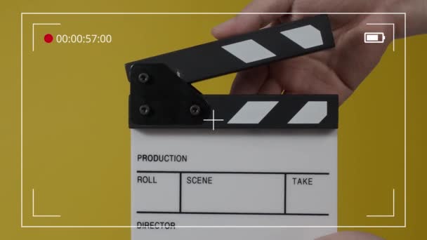 フィルムスレートまたは映画のカメラの記録の前で打つ映画のクラッパーボード 手を閉じて空のフィルムスレートを保持し それを拍手 ビデオ制作のためにフィルムスレートを開いて閉じます 映画製作 — ストック動画