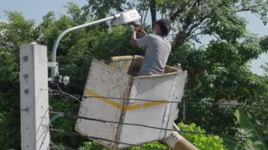 Yükseklik kaldırma platformunda çalışan işçiler yeni sokak lambaları kuruyor. Elektrik işçisi sokak lambasını monte ediyor. Eski lambaları yeni LED ışıklandırmalarla değiştiriyoruz. Teknisyen ışık tamir direği