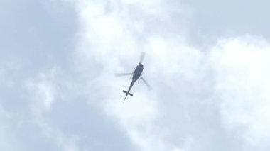 Gökyüzünde uçan helikopter alçak açılı çekim görüntüsü. Helikopter havalandı. Dikey ve yatay hareket edebilme kabiliyeti, hareket yönü pervanenin pervanesi tarafından kontrol edilir..