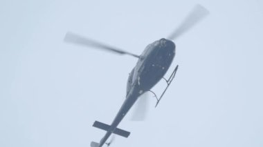 Gökyüzünde uçan helikopter alçak açılı çekim görüntüsü. Helikopter havalandı. Dikey ve yatay hareket edebilme kabiliyeti, hareket yönü pervanenin pervanesi tarafından kontrol edilir..