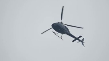 Gökyüzünde uçan helikopter alçak açılı çekim görüntüsü. Helikopter havalandı. Dikey ve yatay hareket edebilme kabiliyeti, hareket yönü pervanenin pervanesi tarafından kontrol edilir..
