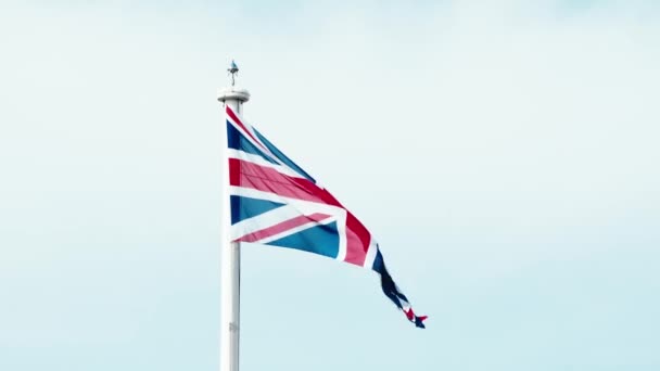 風になびく旗竿にイギリスの本物のユニオンジャックフラグ イギリスの国旗のビデオの風の中で手を振っイギリス イギリスEu離脱 イギリス植民地の国旗 イギリス国旗 — ストック動画