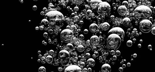 ソーダ水の泡が黒い背景に水中に飛び散る 炭酸飲料の概念をリフレッシュするために水中で爆発のように表面に固定し 浮くコーラの液体のテクスチャ — ストック写真