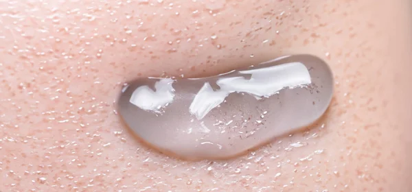 胶原蛋白和透明质血清凝胶在皮肤上 喷溅的透明质凝胶 皮肤上有液体透明质酸凝胶 人类皮肤背景上的复合水凝胶质感 纹理背景 护肤产品 — 图库照片