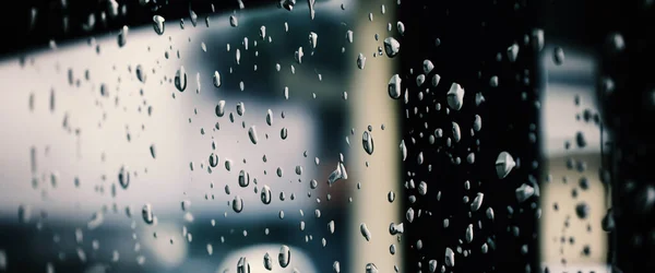 창문에 빗방울이 떨어지고 해진다 장마철이 사람들은 도시의 생활이나 라이트를 됩니다 — 스톡 사진