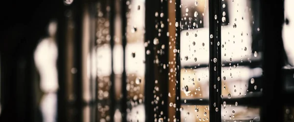 雨滴落在咖啡店的窗玻璃上 模糊了城市生活的背景 多雨的季节和模糊的人们城市的日常生活或者窗外的夜灯 咖啡店橱窗被雨水覆盖 — 图库照片