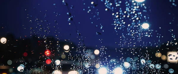 雨の中運転 雨季には車のフロントガラスや車の窓や背景にぼやけたトラフィックの道路に雨 雨が車のミラーに落ちる 雨の中で道路 霧雨の雨は運転の視認性を低下 — ストック写真