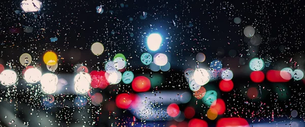 雨の中運転 雨季には車のフロントガラスや車の窓や背景にぼやけたトラフィックの道路に雨 雨が車のミラーに落ちる 雨の中で道路 霧雨の雨は運転の視認性を低下 — ストック写真