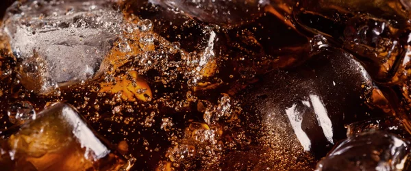 콜라와 얼음을 끓이는 얼음에 튀기거나 떠오르는 것이다 얼음을 닫으세요 음료의 스톡 사진