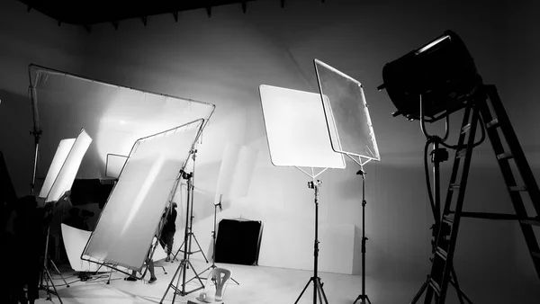 电影摄制组的光人和摄制组的摄影师与导演在大工作室与专业设备合作制作的电视商业电影的幕后或B卷或制作的视频短片的轮廓 — 图库照片