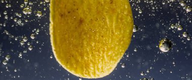 Altın yağlı suyun altında kızarmış patates cipsi. Kızarmış patates cipsi ve kızgın yağ kabarcıkları. Fast food ve aperatif. Su altında yağlı patates kızartması ya da yağlı arka planda patates cipsi.