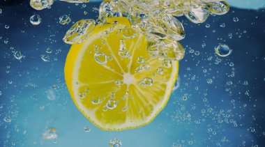 Sodalı limon dilimi ya da köpüklü limonata. Gazoz tonik kokteylini tazeliyorum. Limon ve buzları cama doldur. Su sıçratan limon, soğuk içecek..