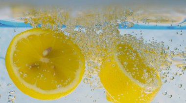 Sodalı limon dilimi ya da köpüklü limonata. Gazoz tonik kokteylini tazeliyorum. Limon ve buzları cama doldur. Su sıçratan limon, soğuk içecek..