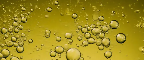 Golden Hyaluron Oil bubbles collagen serum or yellow oil bubbles drop texture background. Liquid transparent droplets. Skincare essential product with dribs. Honey syrup bubble. Oil droplets close up