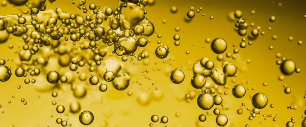 Golden Hyaluron Oil bubbles collagen serum or yellow oil bubbles drop texture background. Liquid transparent droplets. Skincare essential product with dribs. Honey syrup bubble. Oil droplets close up