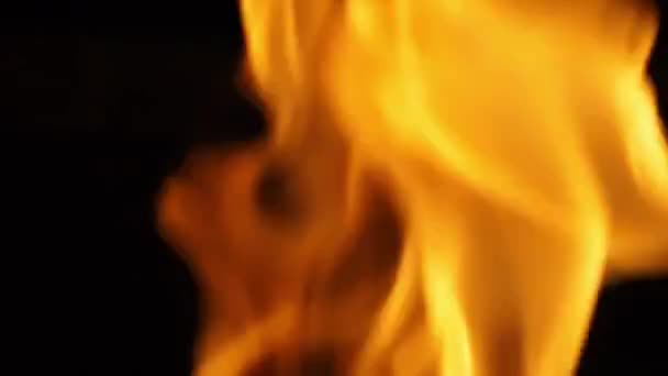 火の振動を示し 熱を表し 何かを破壊したり損傷したりする黒い背景に対して燃える火災の映像を閉じます 赤い火のグリルと調理する ハンドヘルドカメラスタイル — ストック動画