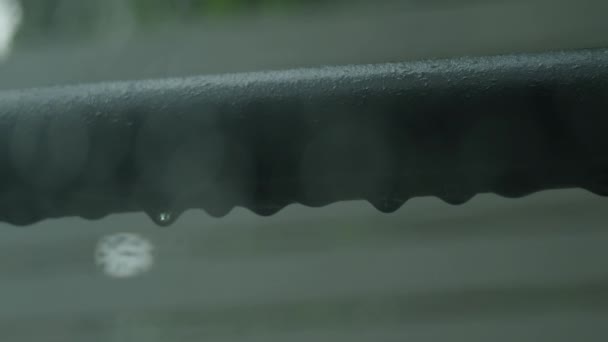 雨に覆われた映像を雨が降った後 ウィンドウを介して静止したカメラは 衣服のラックとぼやけた背景にスティックします 雨の後 冷静でリラックスした時間をお過ごしください 雨季の気象報告コンセプト — ストック動画
