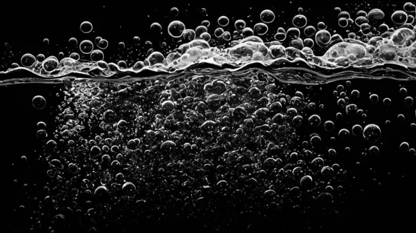 Soda water bubbles splashing underwater against black background. Soda liquid texture that fizzing and floating up to surface like a explosion in under water for refreshing carbonate drink concept.