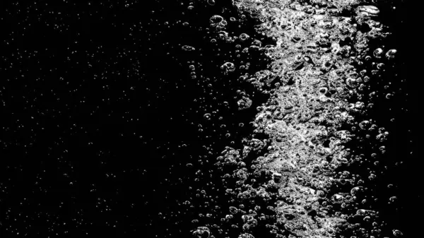 Soda water bubbles splashing underwater against black background. Soda liquid texture that fizzing and floating up to surface like a explosion in under water for refreshing carbonate drink concept.