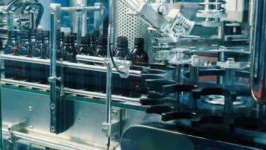Modern fabrikada şişeler otomasyon makinesini dolduruyor. Endüstrideki şişeleri doldurma ve kapama teknolojisi gösterisi. Kusurlu ilaç şişelerinin incelenmesi. İlaç ve içecek imalatı.