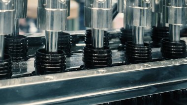 Modern fabrikada şişeler otomasyon makinesini dolduruyor. Endüstrideki şişeleri doldurma ve kapama teknolojisi gösterisi. Kusurlu ilaç şişelerinin incelenmesi. İlaç ve içecek imalatı.