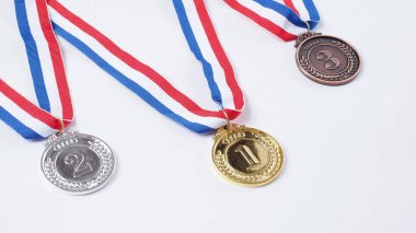 Okul, ulusal ya da olimpiyat sporları yarışmaları için kurdeleli altın ve bronz kupa madalyaları. Beyaz arka planda izole edilmiş. Ödül ve zafer konsepti