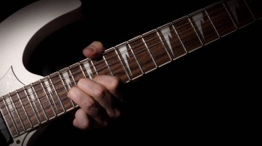 Gitarist stüdyoda gitar çalıyor. Alçakgönüllü bir adam beyaz elektro gitar çalar şarkılar ve kapak müziği ya da yetenek pratiği için. Siyah arkaplana karşı gitar çalan müzisyenleri kapat