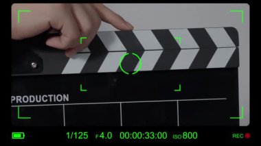 Film tahtası ya da el çırpma tahtası kayıt çerçevesiyle vuruyor. El ele tutuşup boş film tahtasını tutarak ve kameranın önünde alkışlayarak. Bir video prodüksiyonu çekerken açık ve kapalı film sayfası