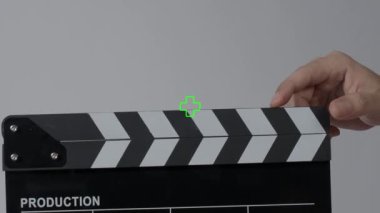 Film tahtası ya da el çırpma tahtası kayıt çerçevesiyle vuruyor. El ele tutuşup boş film tahtasını tutarak ve kameranın önünde alkışlayarak. Bir video prodüksiyonu çekerken açık ve kapalı film sayfası