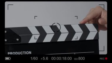 Film tahtası ya da el çırpma tahtası kayıt çerçevesiyle vuruyor. El ele tutuşup boş film tahtasını tutarak ve kameranın önünde alkışlayarak. Bir video prodüksiyonu çekerken açık ve kapalı film sayfası