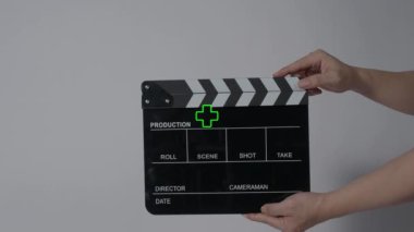 Film tahtası ya da el çırpma tahtası kayıt çerçevesiyle vuruyor. El ele tutuşup boş film tahtasını tutarak ve kameranın önünde alkışlayarak. Bir video prodüksiyonu çekerken açık ve kapalı film sayfası