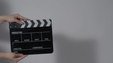 Film tahtası ya da el çırpma tahtası kayıt çerçevesiyle vuruyor. El ele tutuşup boş film tahtasını tutarak ve kameranın önünde alkışlayarak. Bir video prodüksiyonu çekerken açık ve kapalı film sayfası